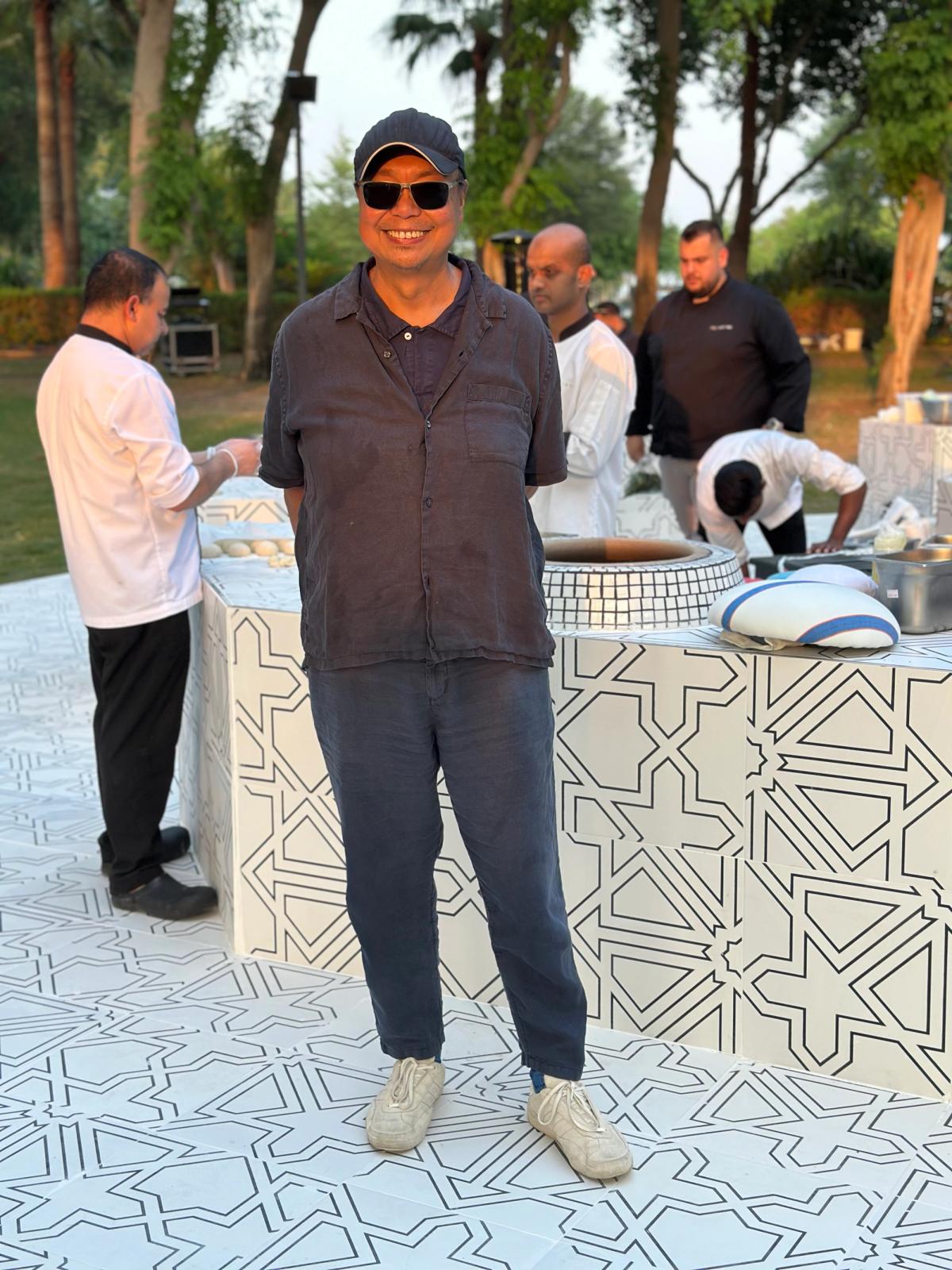 Rirkrit Tiravanija devant son œuvre untitled 2025 (no bread no ashes) le 29 octobre 2025 à Doha. Photo : Philippe Régnier 