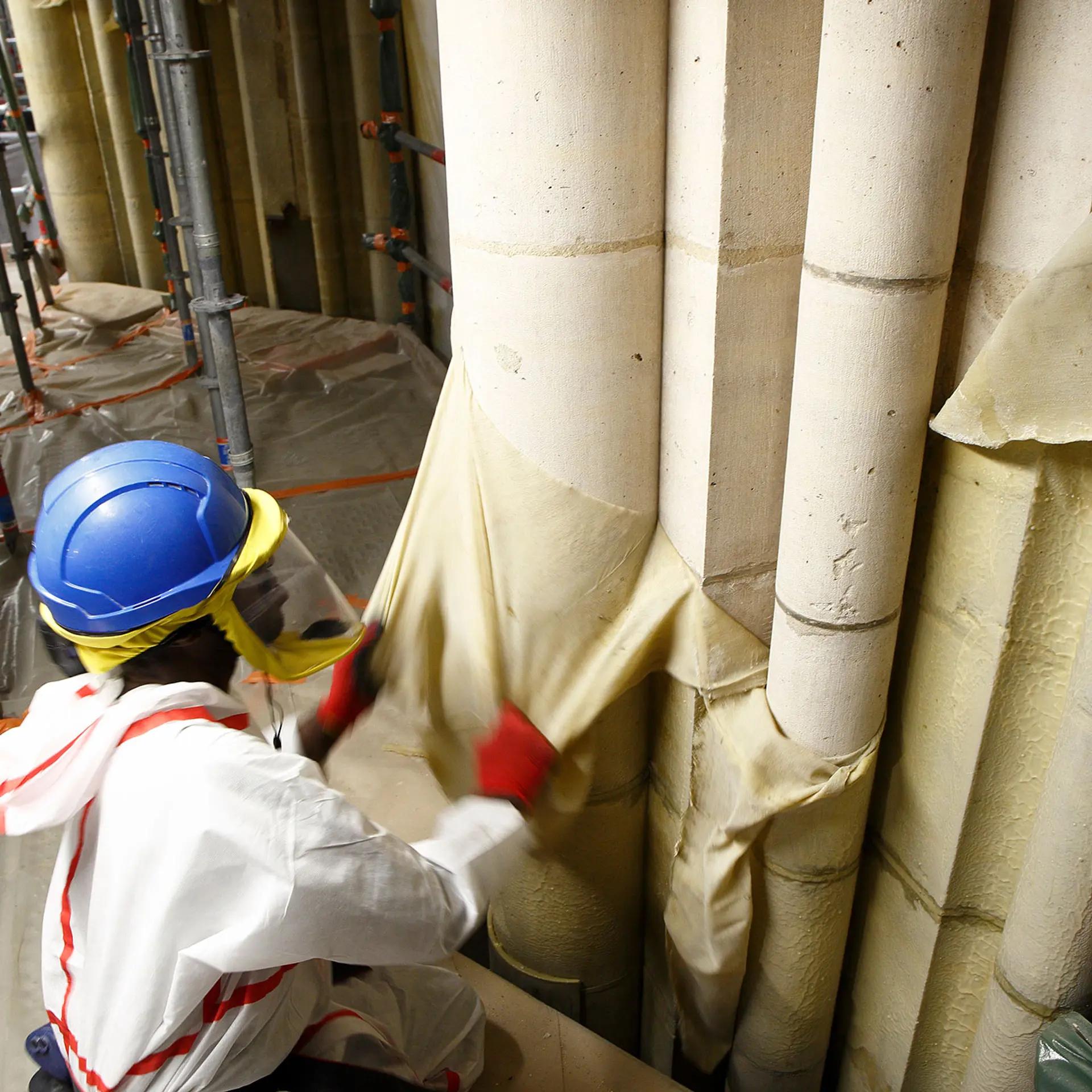 Un technicien enlève la membrane de nettoyage en latex lors de la restauration de la maçonnerie de Notre-Dame de Paris. © David Bordes / Établissement public chargé de la conservation et de la restauration de la cathédrale Notre-Dame de Paris