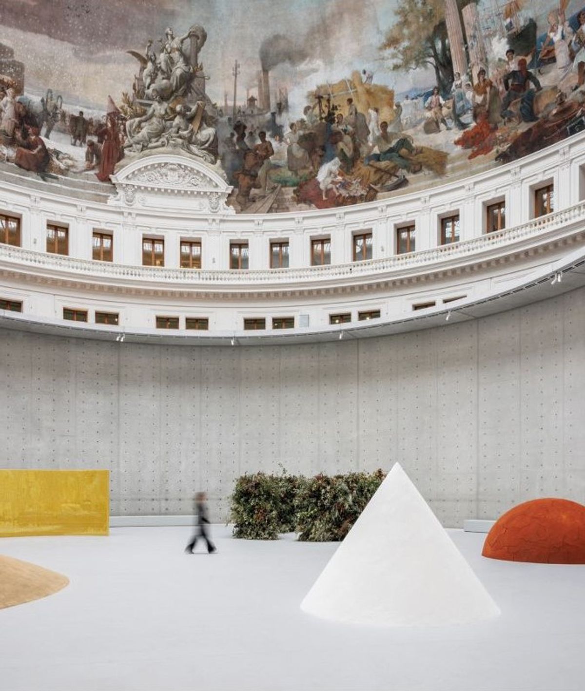 De gauche à droite : Meg Webster, Walls of Beeswax (1990, cire), Circle of Branches (2025, feuilles, fleurs et brindilles), Cone of Salt (1988, sel) et Mother Mound (1990, terre rouge), Bourse de Commerce – Pinault Collection, Paris, 2025. © Meg Webster. Courtesy de la Pinault Collection. Photo Florent Michel/11h45