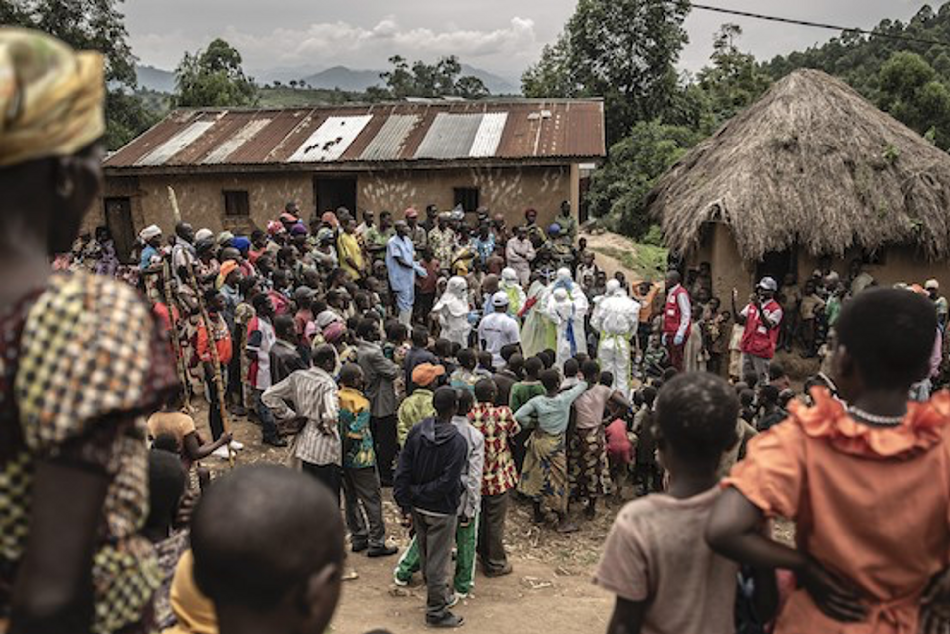 Des voisins et employés de la Croix Rouge en tenue de protection rassemblés devant le domicile d’une fillette de 11 mois, décédée lors de l’épidémie d’Ebola au Nord-Kivu, février 2020. © Finbarr O’Reilly pour la Fondation Carmignac