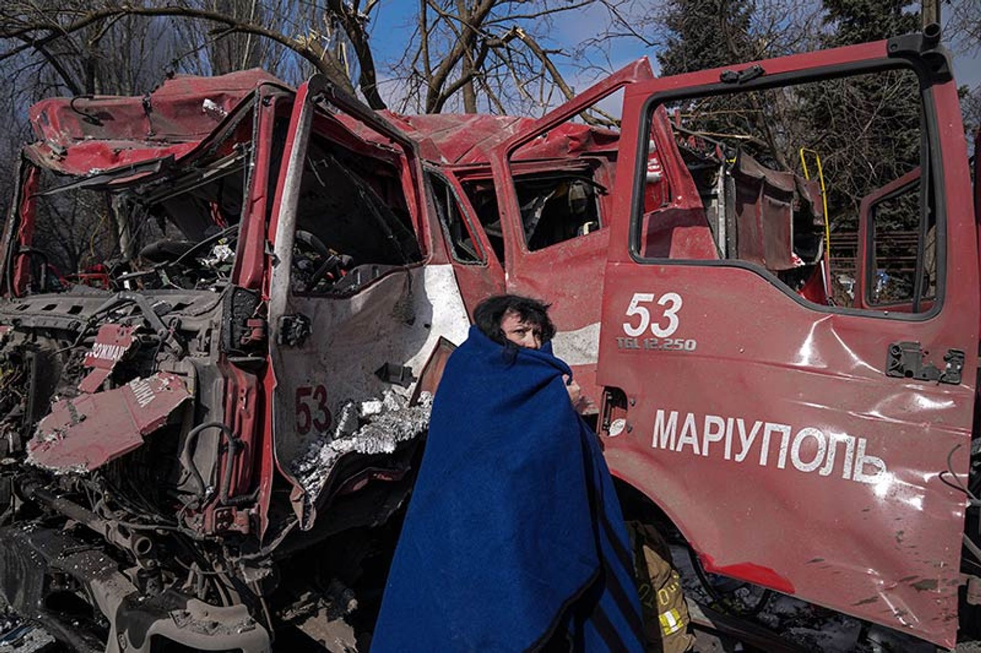 Evgeniy Maloletka, Une femme devant un camion de pompiers détruit par des tirs d’obus. Marioupol, Ukraine, 10 mars 2022. © Evgeniy Maloletka / Associated Press

