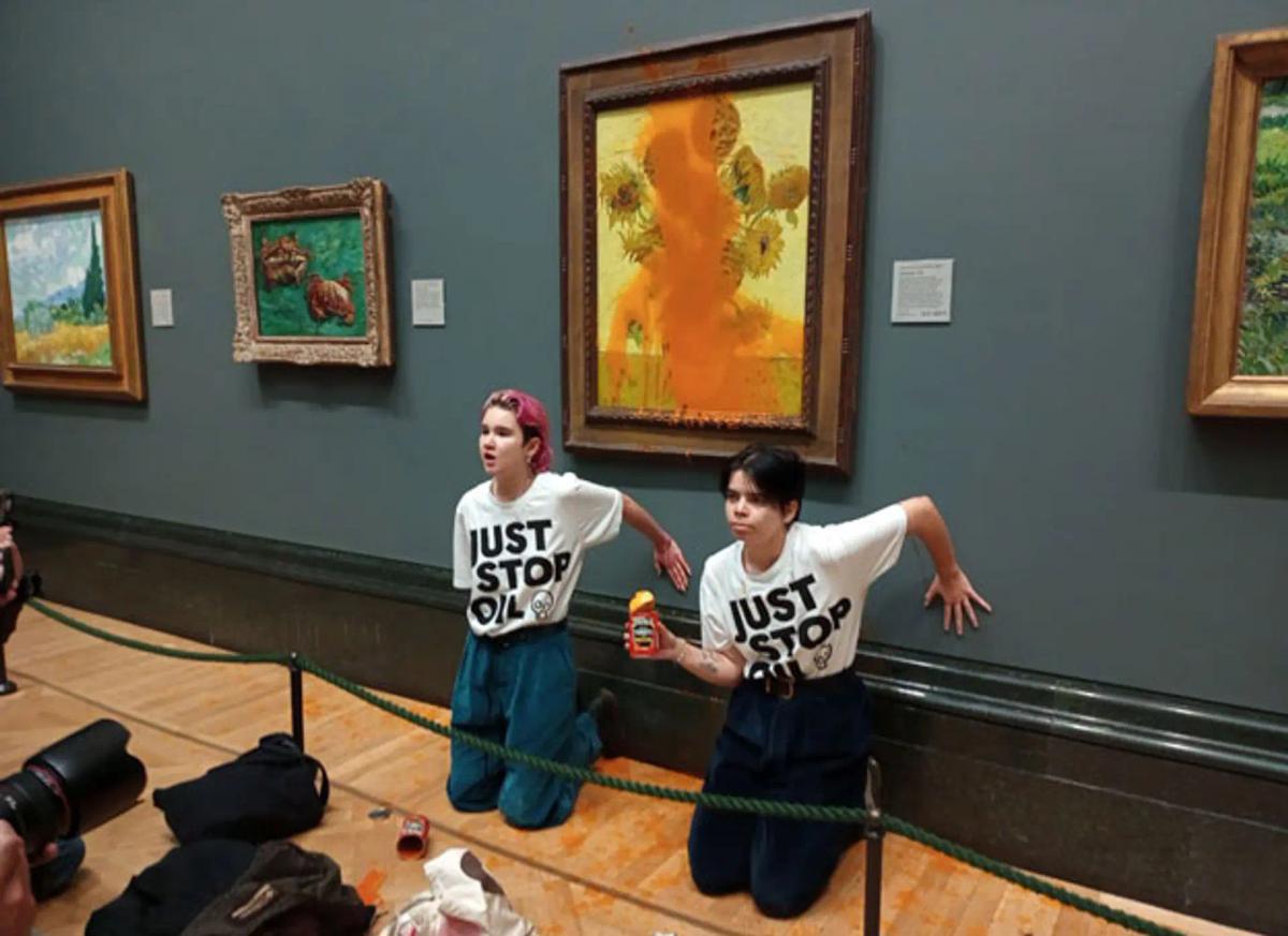 Deux militantes du groupe Just Stop Oil ont collé leurs mains au mur après avoir aspergé de sauce tomate les Tournesols (1888) de Van Gogh à la National Gallery de Londres, le 14 octobre. Photo : Just Stop Oil
