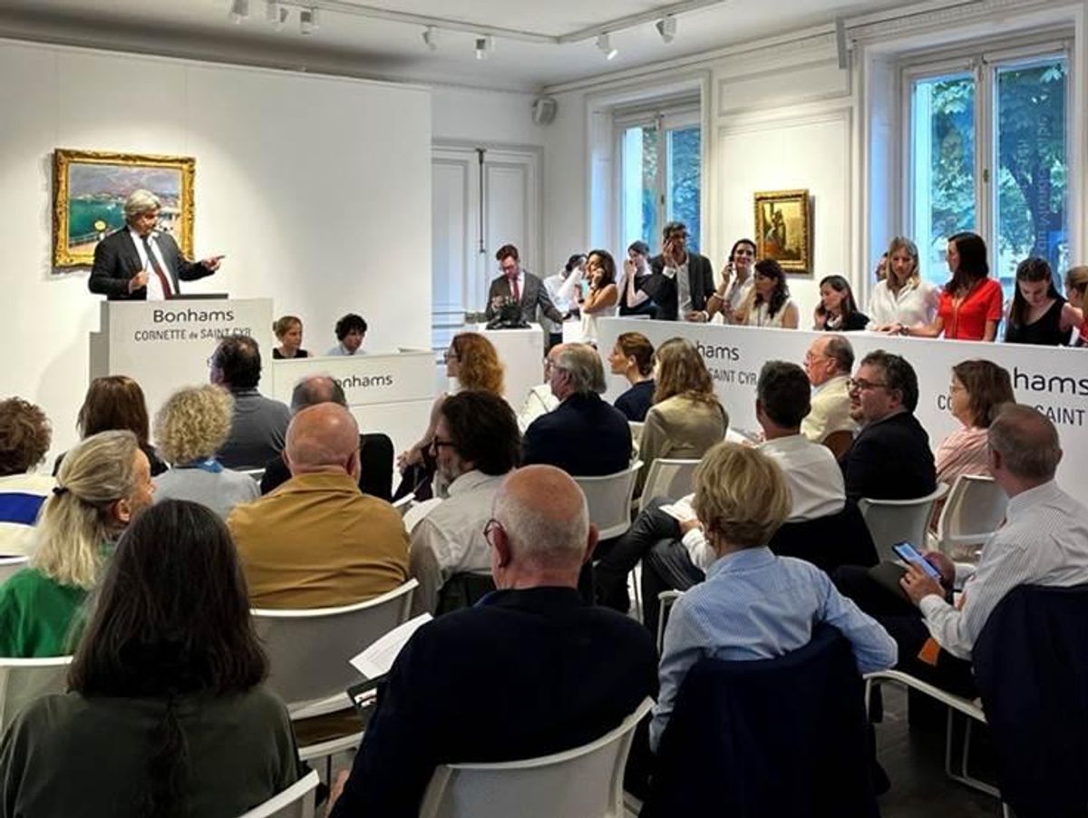 Arnaud Cornette de Saint Cyr, président de Bonhams Cornette de Saint Cyr, dispersant la collection d'Alain Delon. Derrière lui, La baie de Sainte-Adresse, par Raoul Dufy. Photo : Bonhams Cornette de Saint Cyr