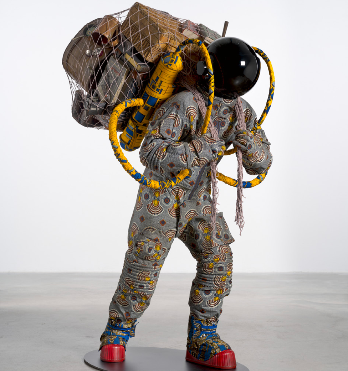 Yinka Shonibare, Refugee Astronaut XII, 2024. Sculpture en fibre de verre, tissu « Dutch wax », filet, effets personnels, casque d'astronaute et bottes lunaires. 190 x 101 x 114 cm. © Yinka Shonibare, Adagp, Paris, 2026.
Photo. Archives Mennour. Courtesy de l'artiste et Mennour, Paris
