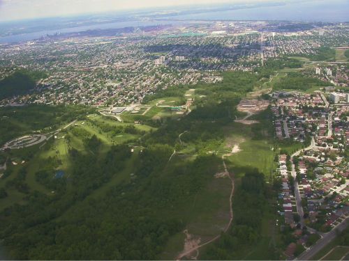 An arial shot of a green space bordering a suburb.