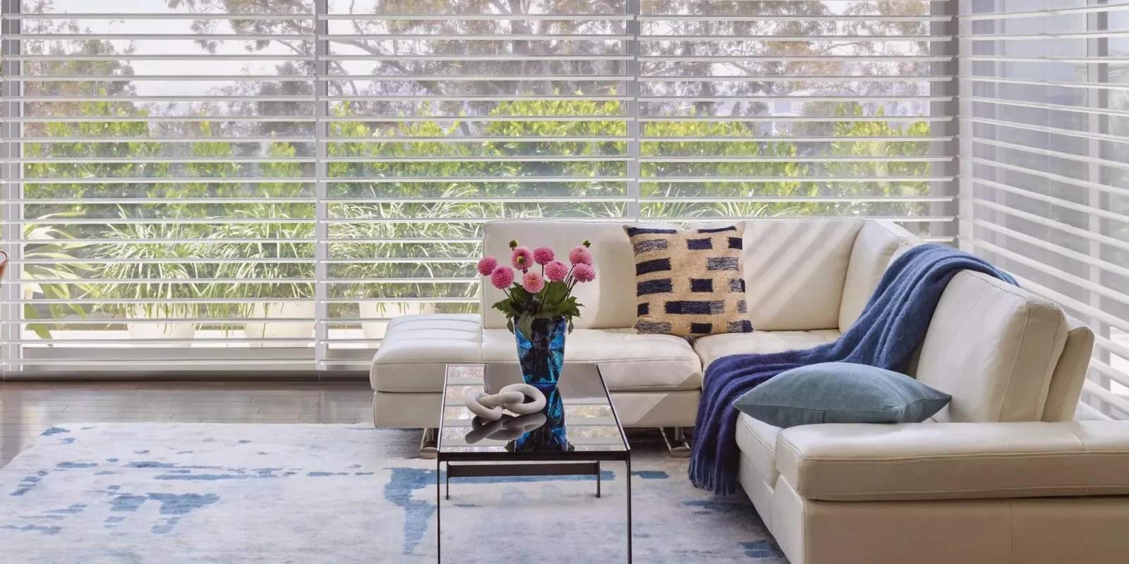 Sunlit living pièce with sheer Hunter Douglas shades filtering soft daylight across a tailored interior