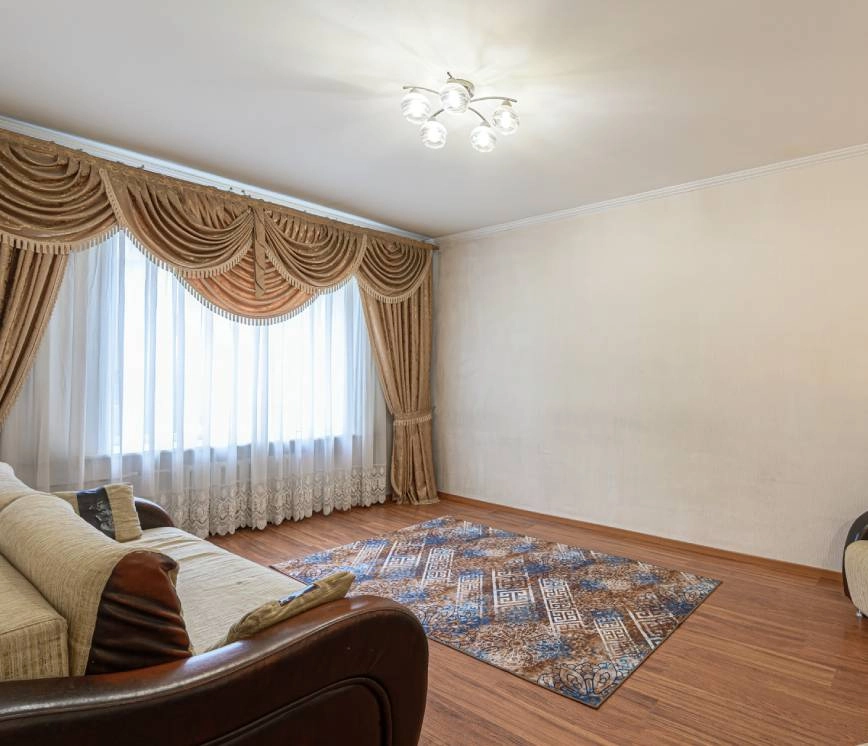 A window top treatment covering a window that has white and gold drapery.
