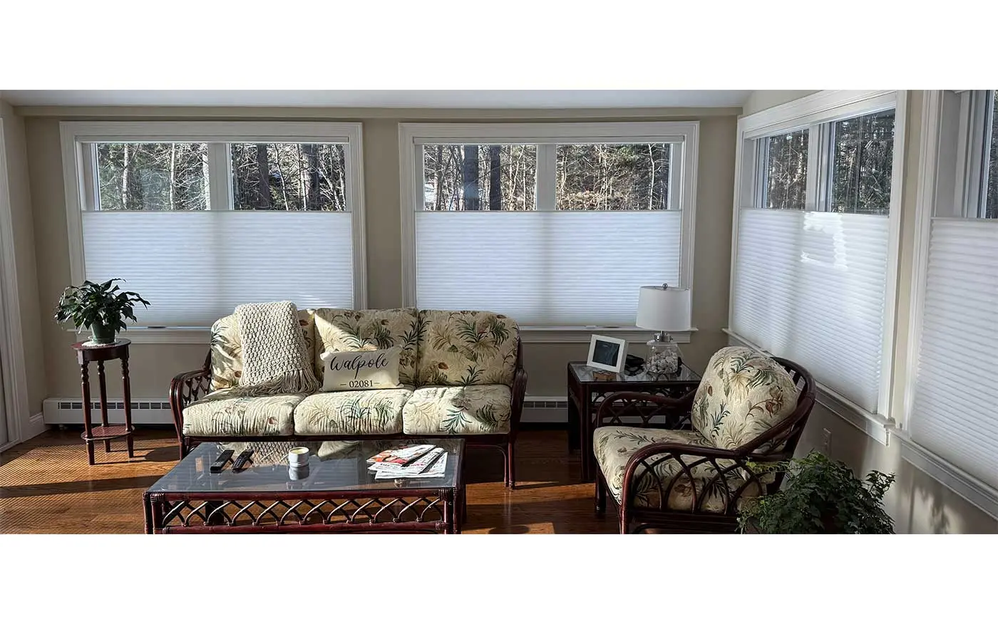 A living room with large windows featuring Hunter Douglas shades.
