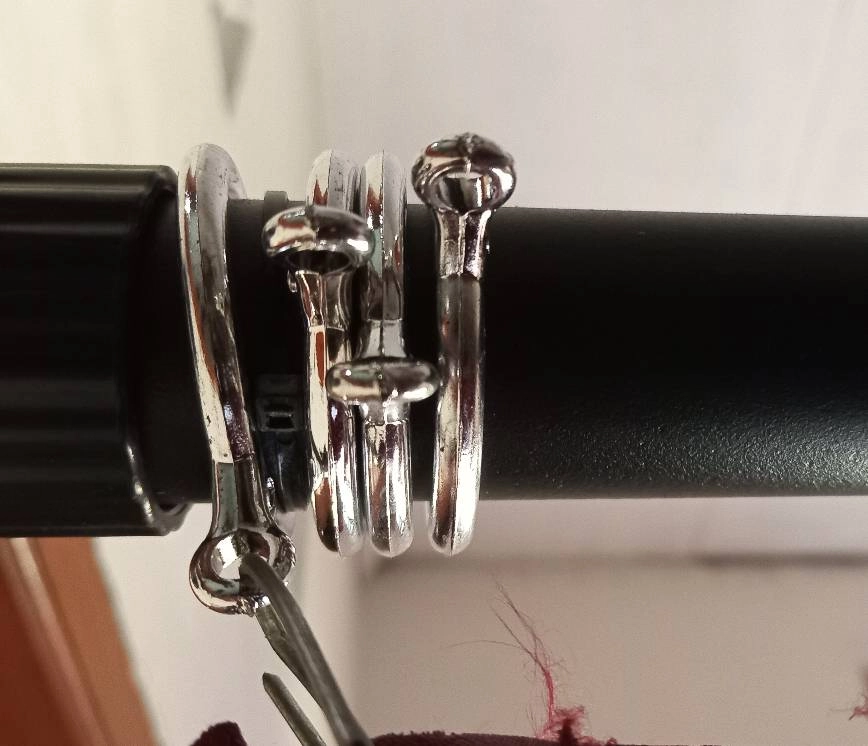 Black drapery rod with silver rings.