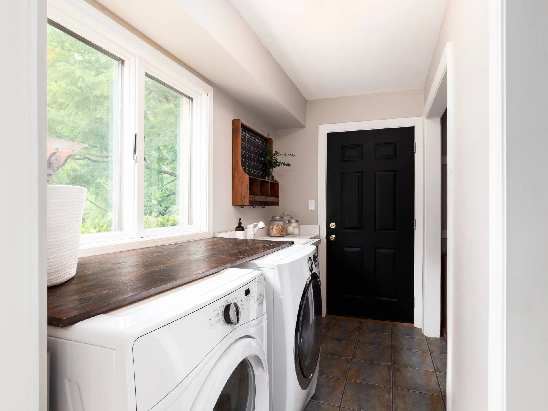A well-designed laundry room with windows in need of window coverings near Council Bluffs, IA