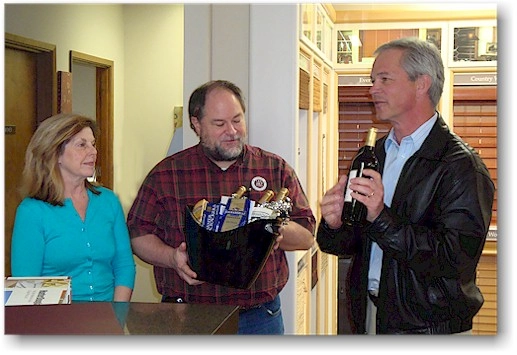 Paul Fergen of Hunter Douglas Northwest presenting a gift of cheese and wine to Kurt and Claudia Evers owners of The Blind Alley to celebrate the 25th Anniversary of The Blind Alley in 2009