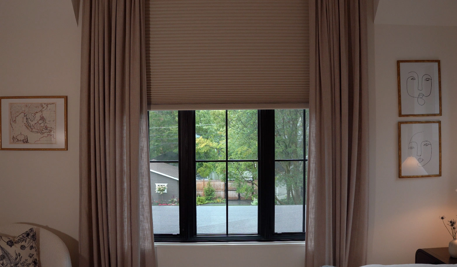 A bedroom window with drapery and Hunter Douglas shades.