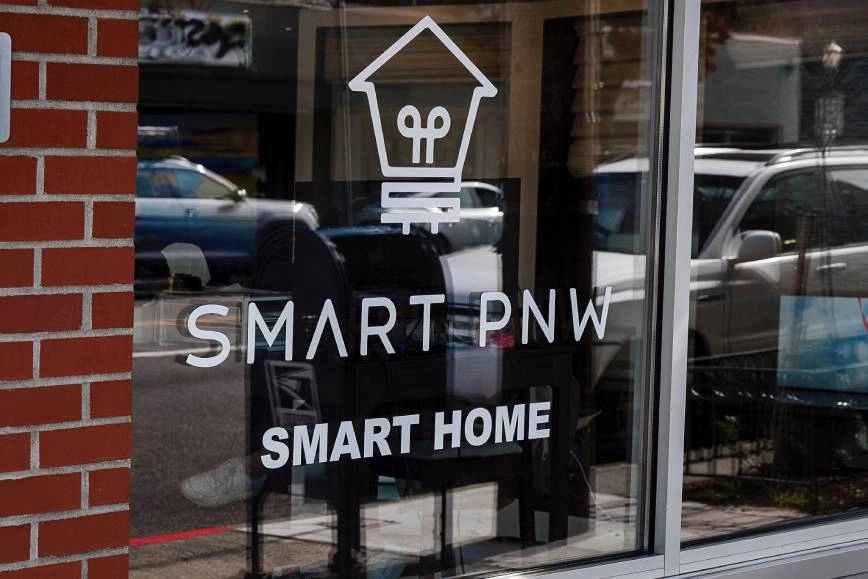 The storefront window features their logo and displays text that says "Smart PNW" and "Smart Home."