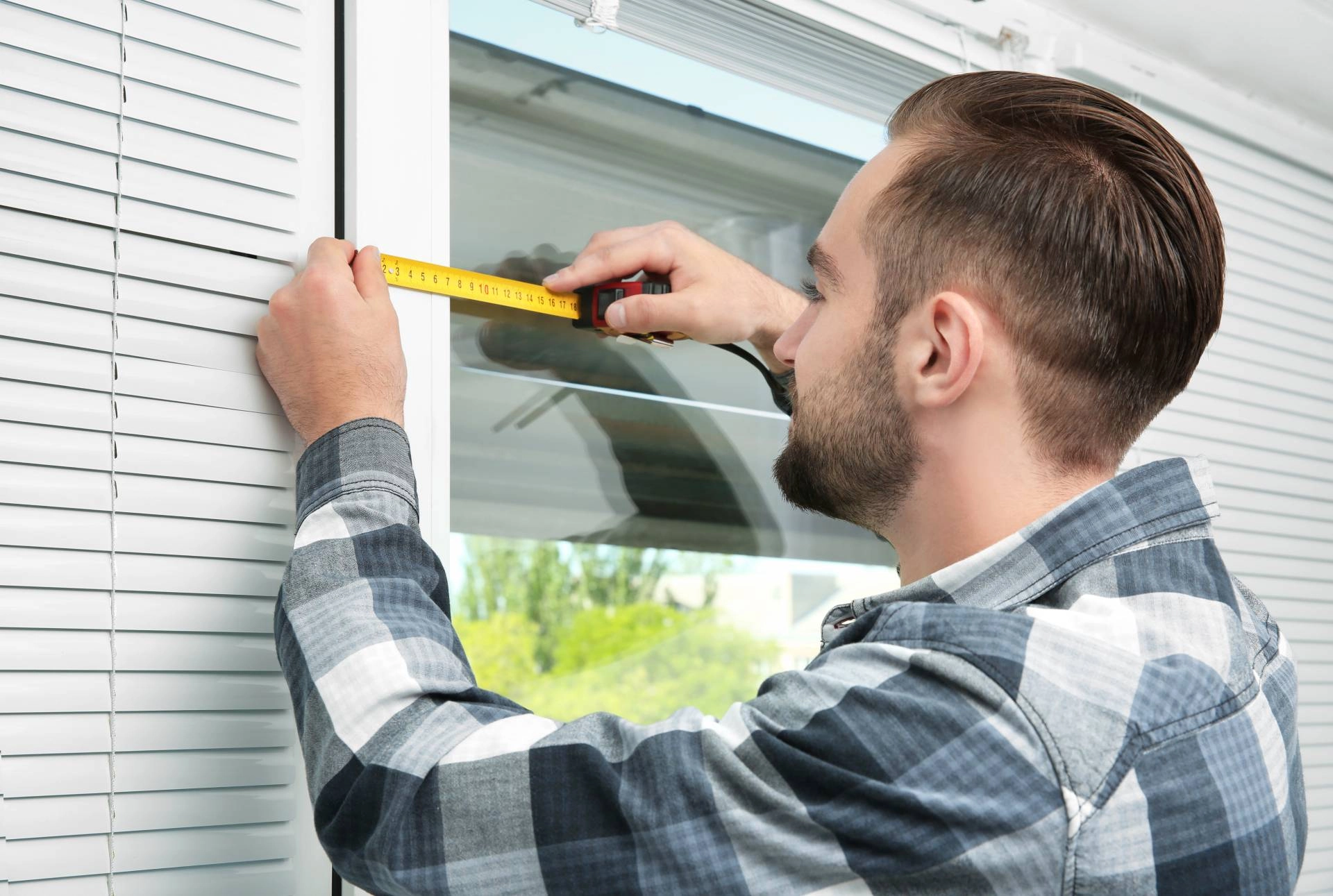 Someone installing a new set of window blinds near Apex, NC