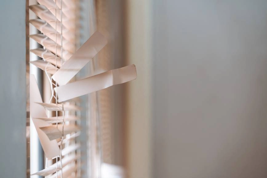 Window blinds with severely broken slats.
