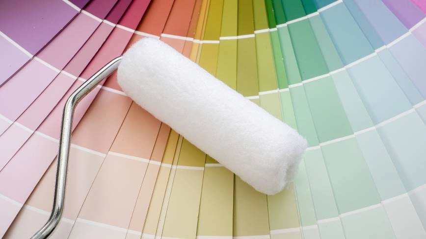 Clean paint roller on top of colorful paint samples.