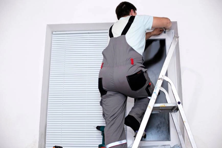 Window treatment professional repairing window blinds.