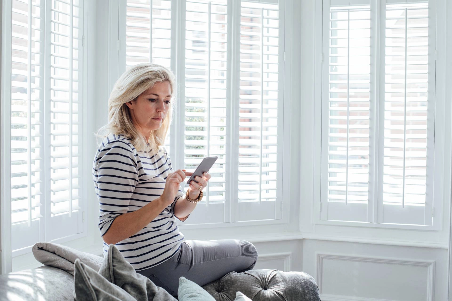 Someone sitting in their bay window with several sets of interior shutters near Midway, Utah