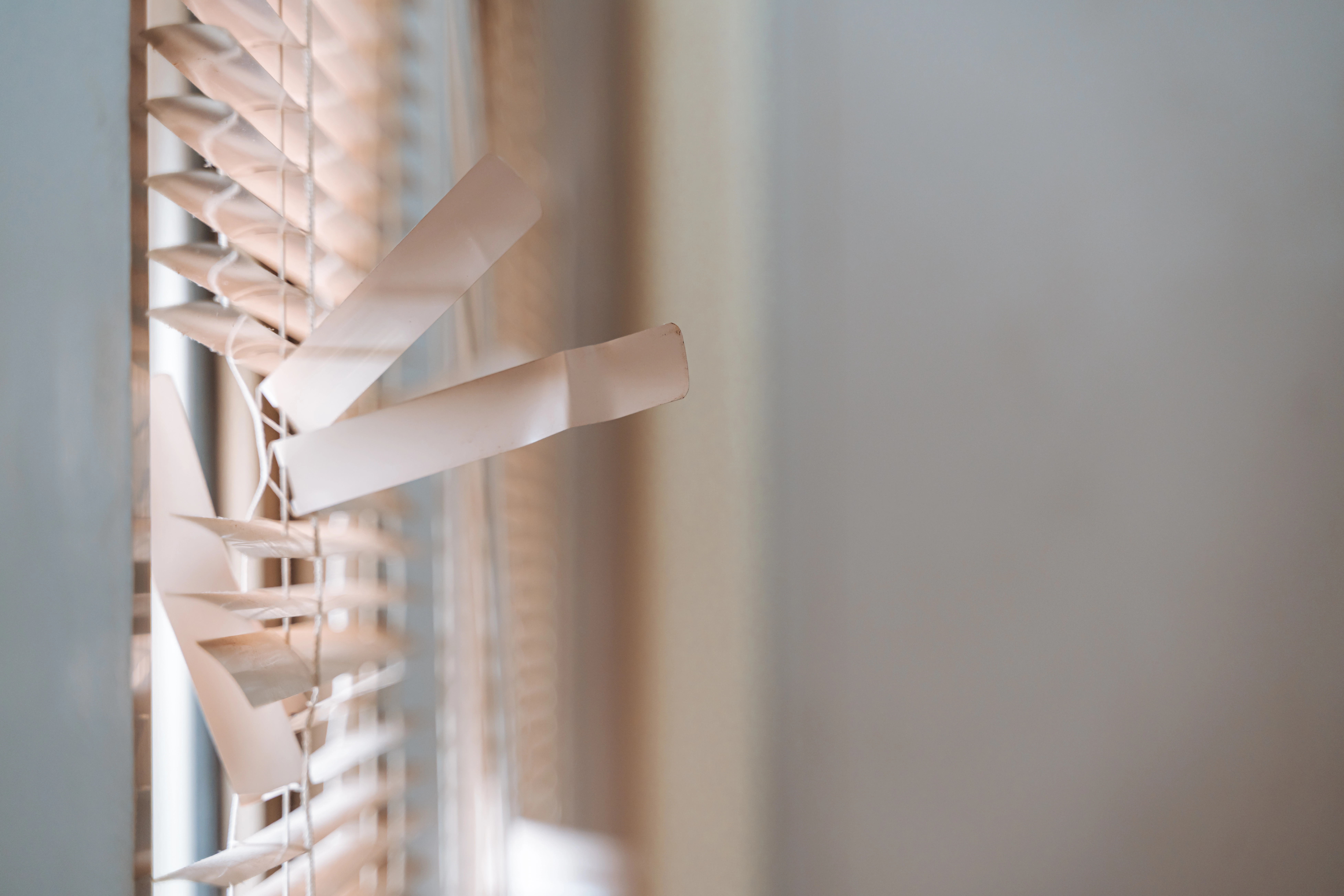 A set of broken blinds covering a window near Estero, FL