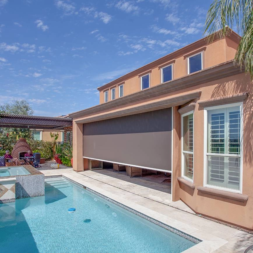 Large outdoor shade blocking light on a seating area beside a pool.