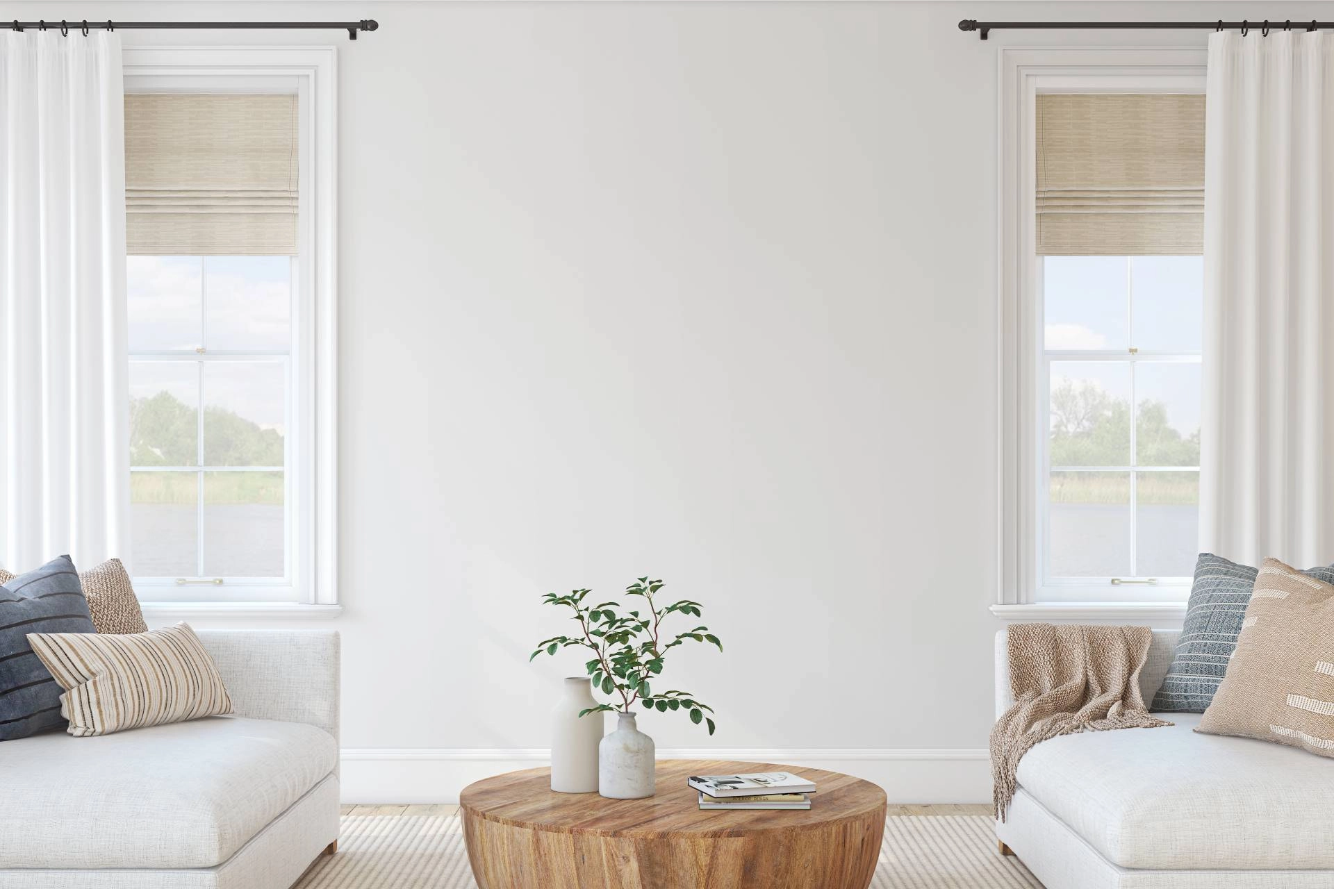 Coastal interior design living room and windows with woven wood shades layered with white drapes