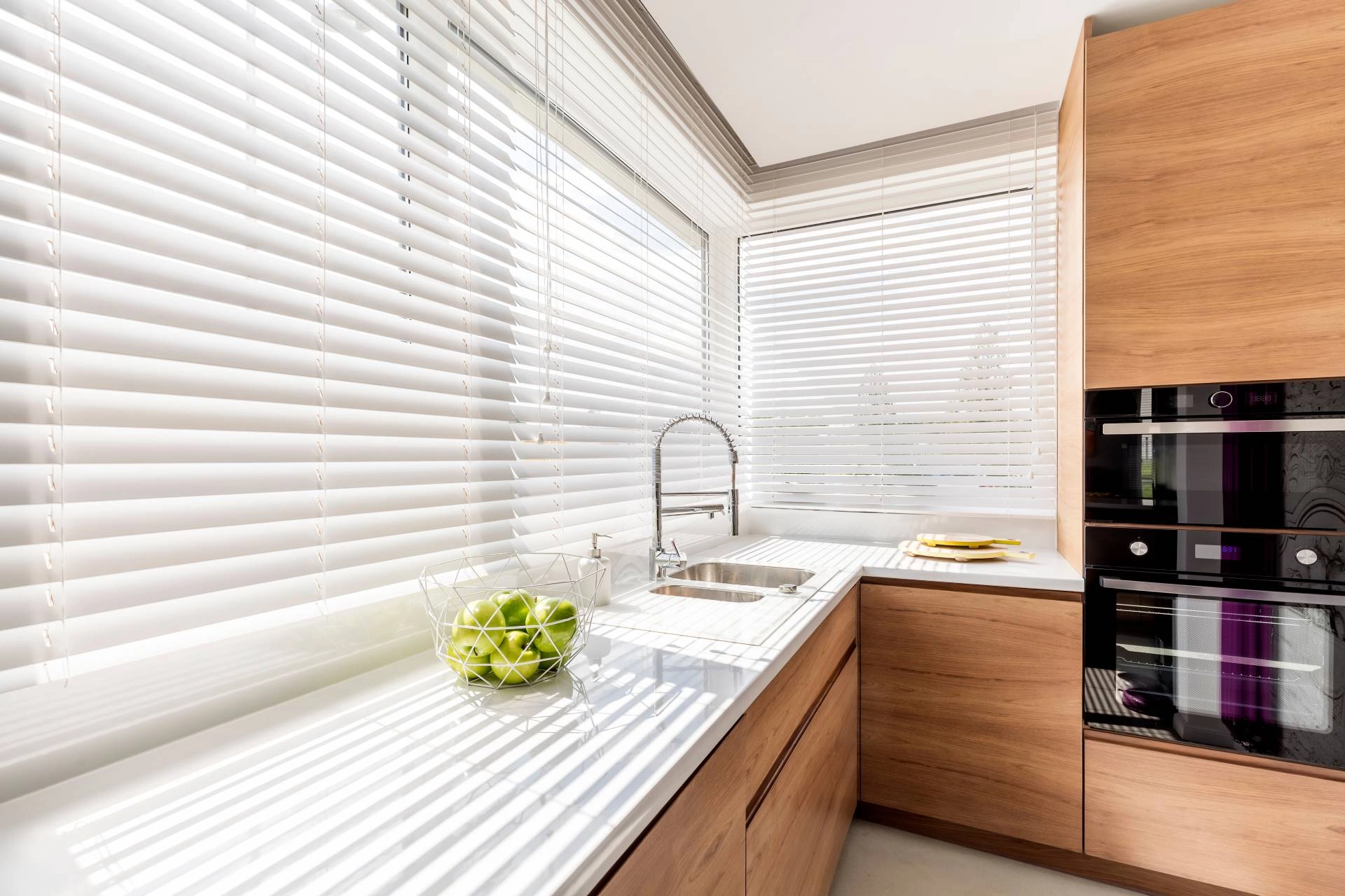 Custom window blinds covering a kitchen window behind a sink near Freeland, MI