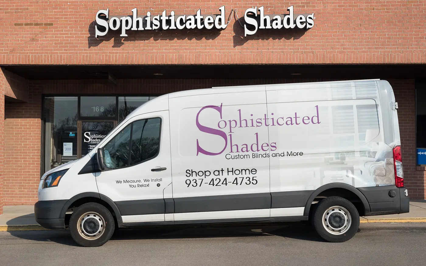 A living room with large windows featuring Hunter Douglas shades.