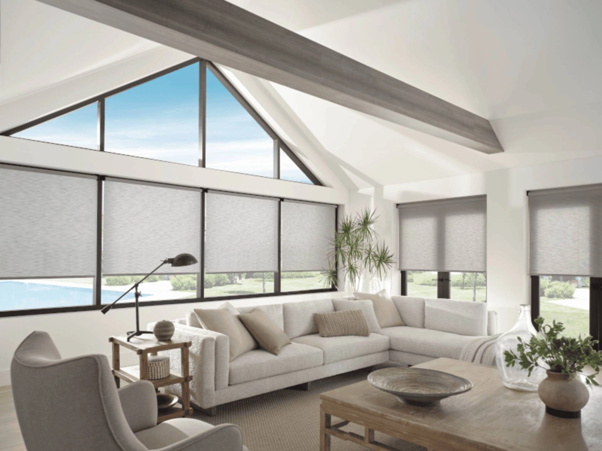 Gray Hunter Douglas Designer Screen Shades on large windows in a sunny modern living room.