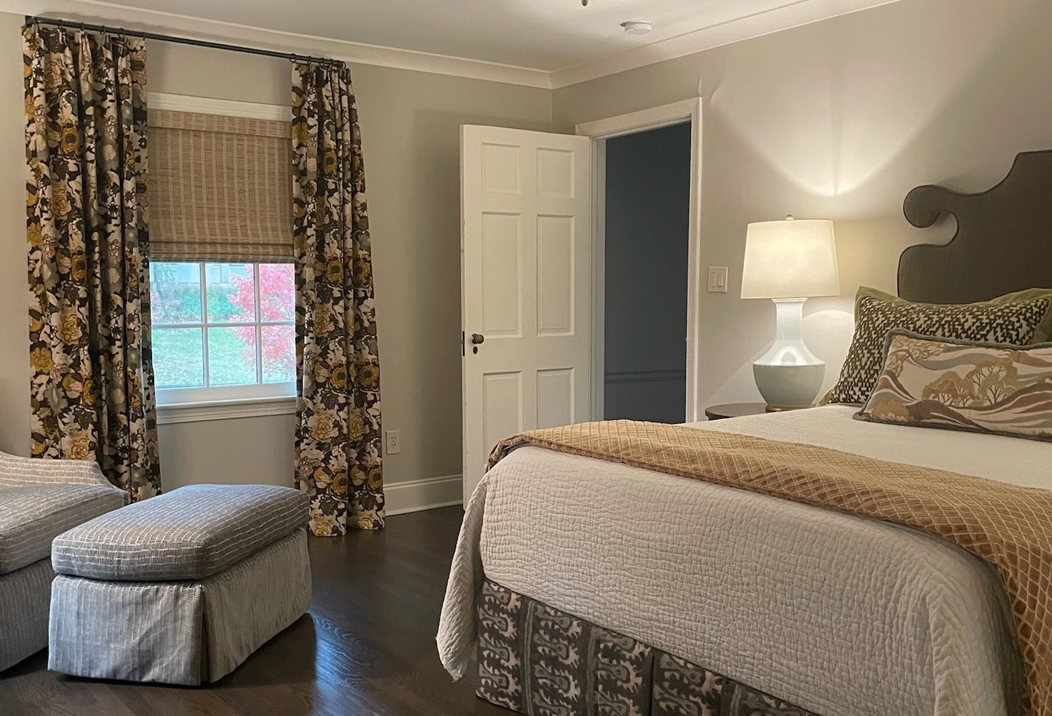 Bedroom with shades and drapery.