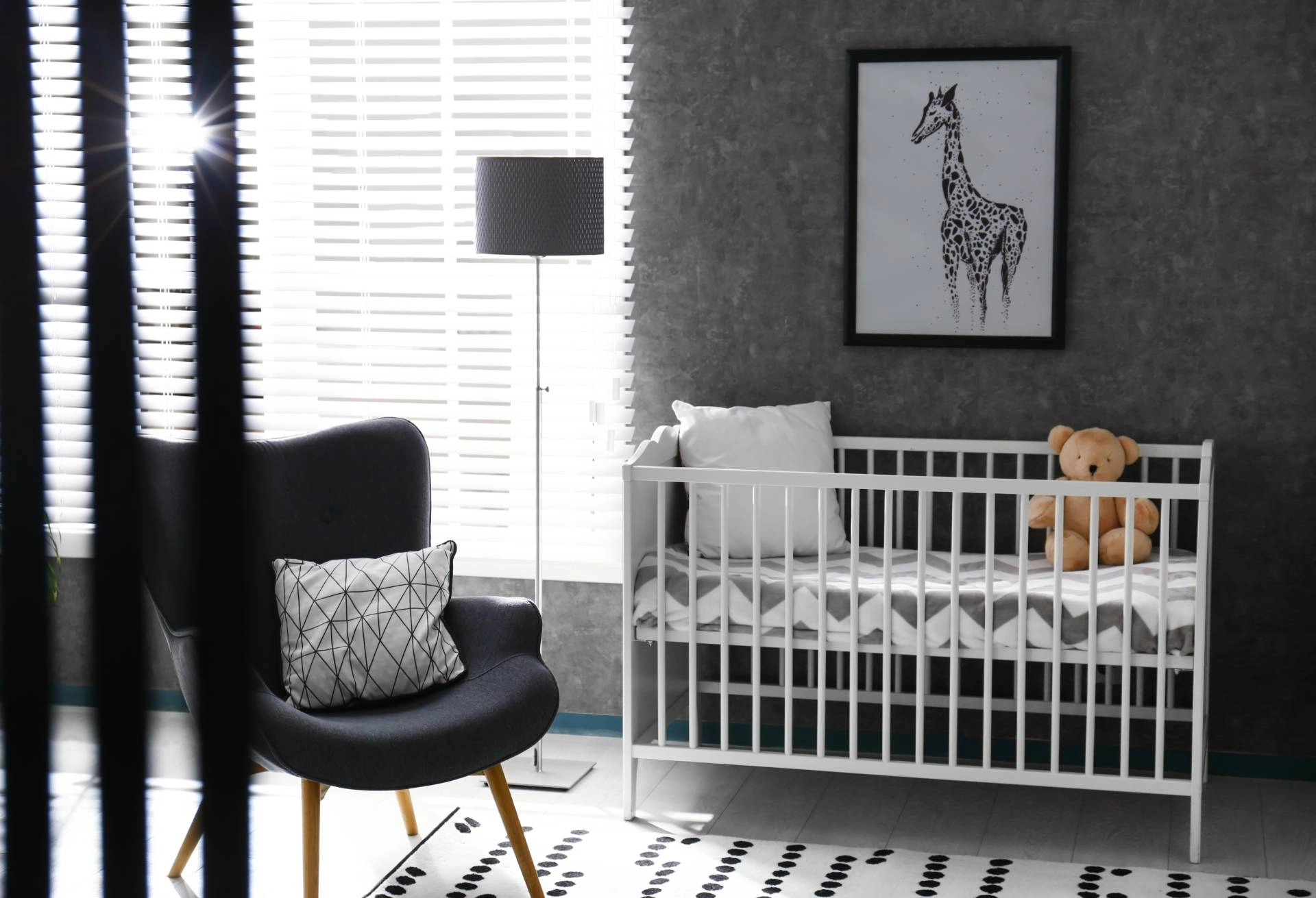 A baby's nursery with a gray and minimalist theme and child-safe window blinds near the crib