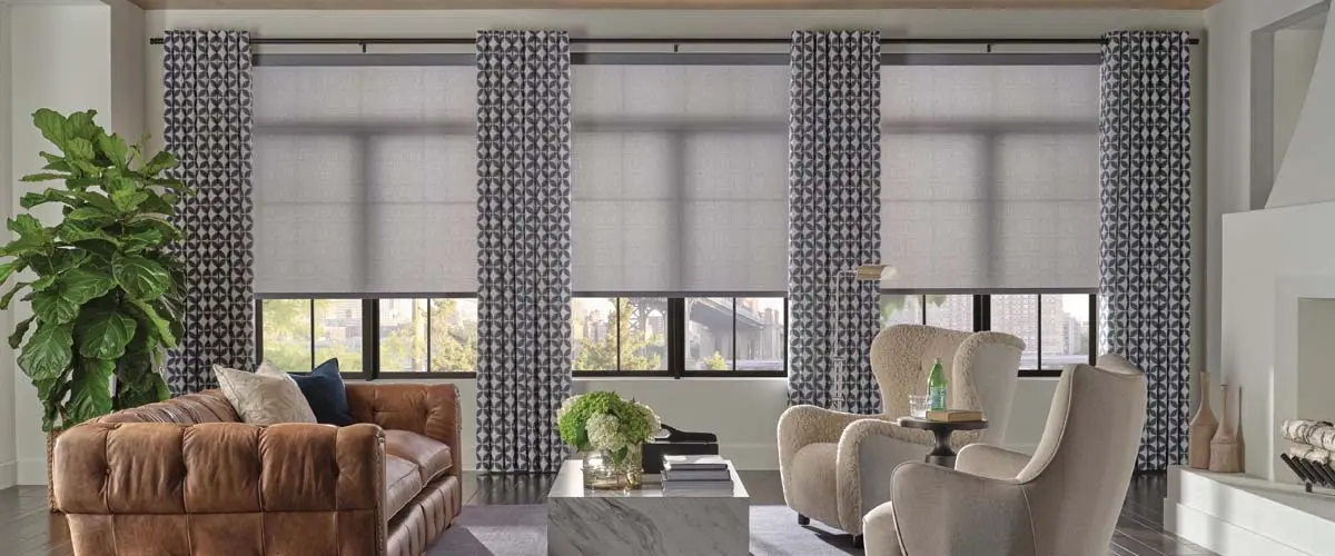 A living room with large windows featuring Hunter Douglas shades.