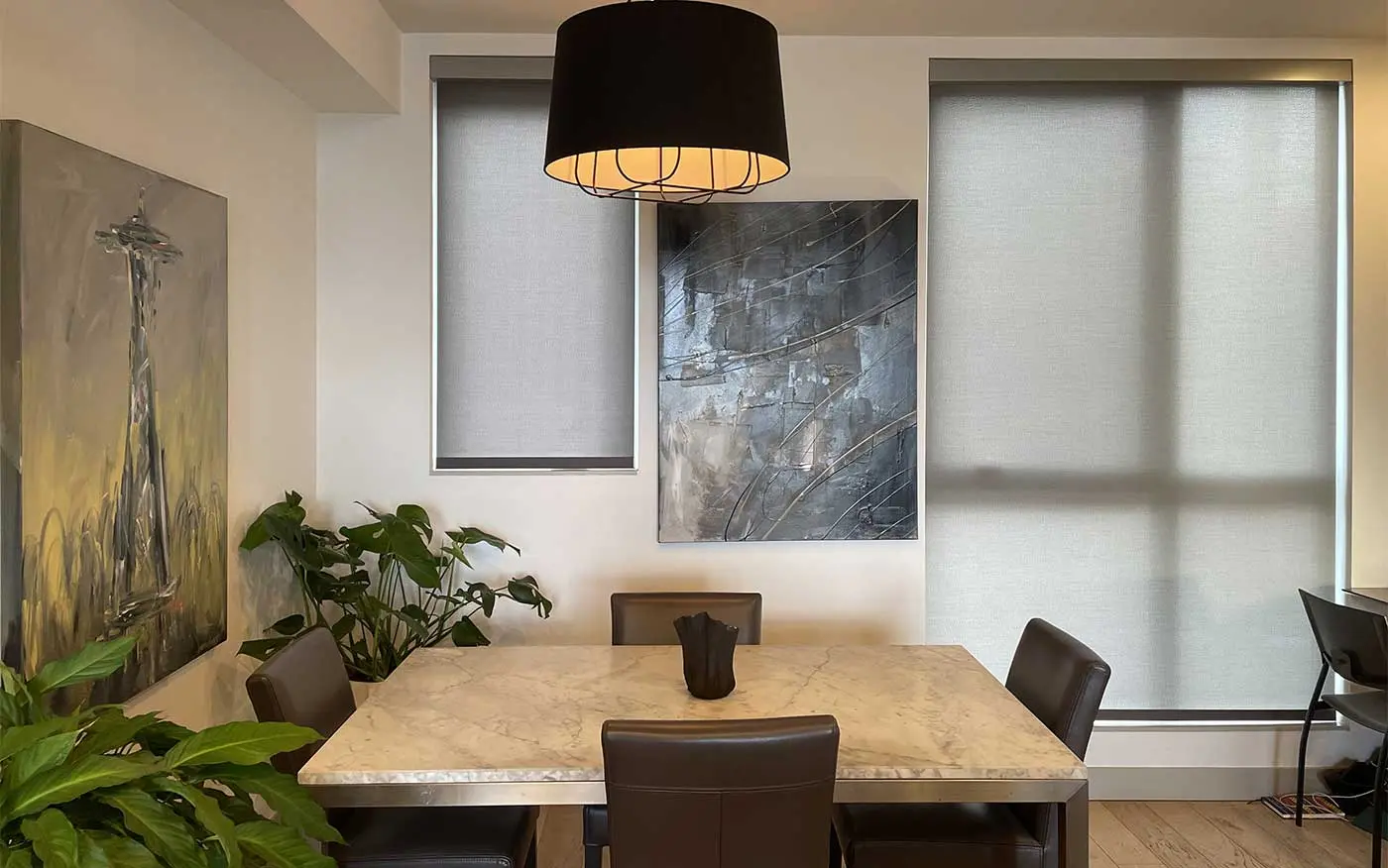 A dining room with windows featuring Hunter Douglas shades.