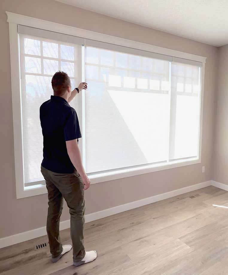 A man testing his honeycomb shades
