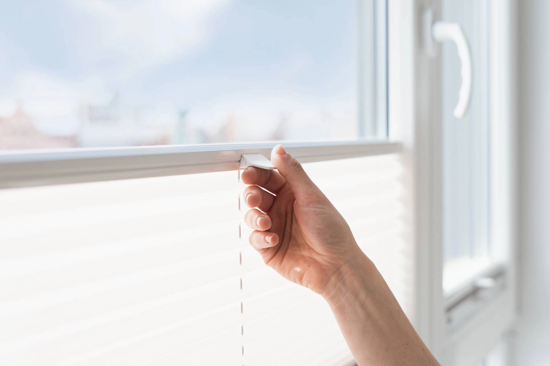 Person's hand pushing up a cordless window shade on a window near Rohnert Park, CA