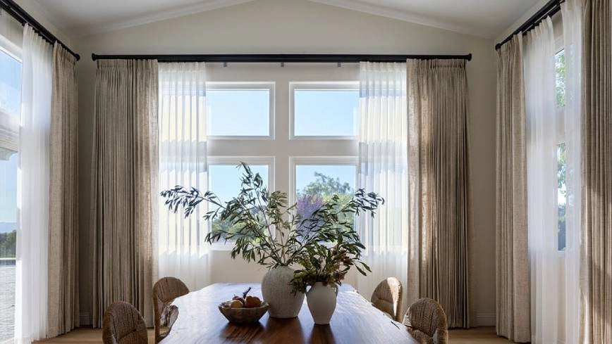 Custom drapery framing floor-to-ceiling living room windows