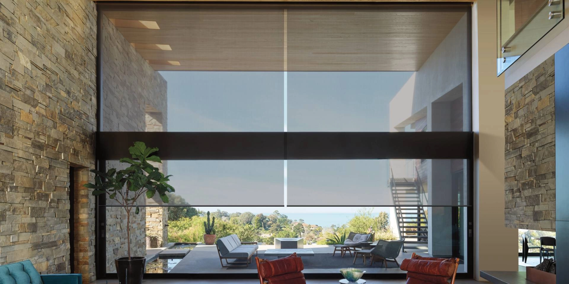 Hunter Douglas roller shades as window treatments for floor-to-ceiling windows in a living room