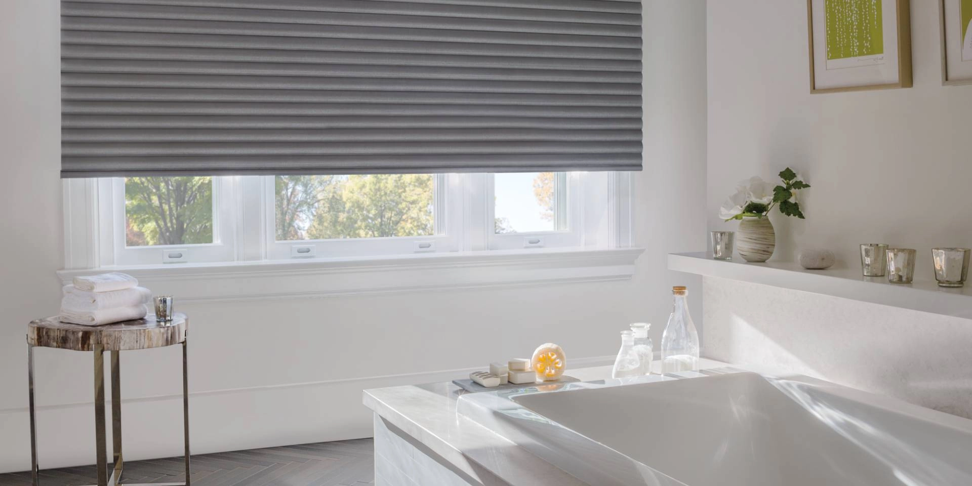Hunter Douglas Sonnette® Roller Shades on a large window in a bathroom with a soaking tub