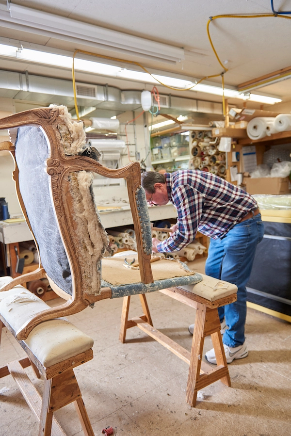 Joe doing upholstery work on a chair.