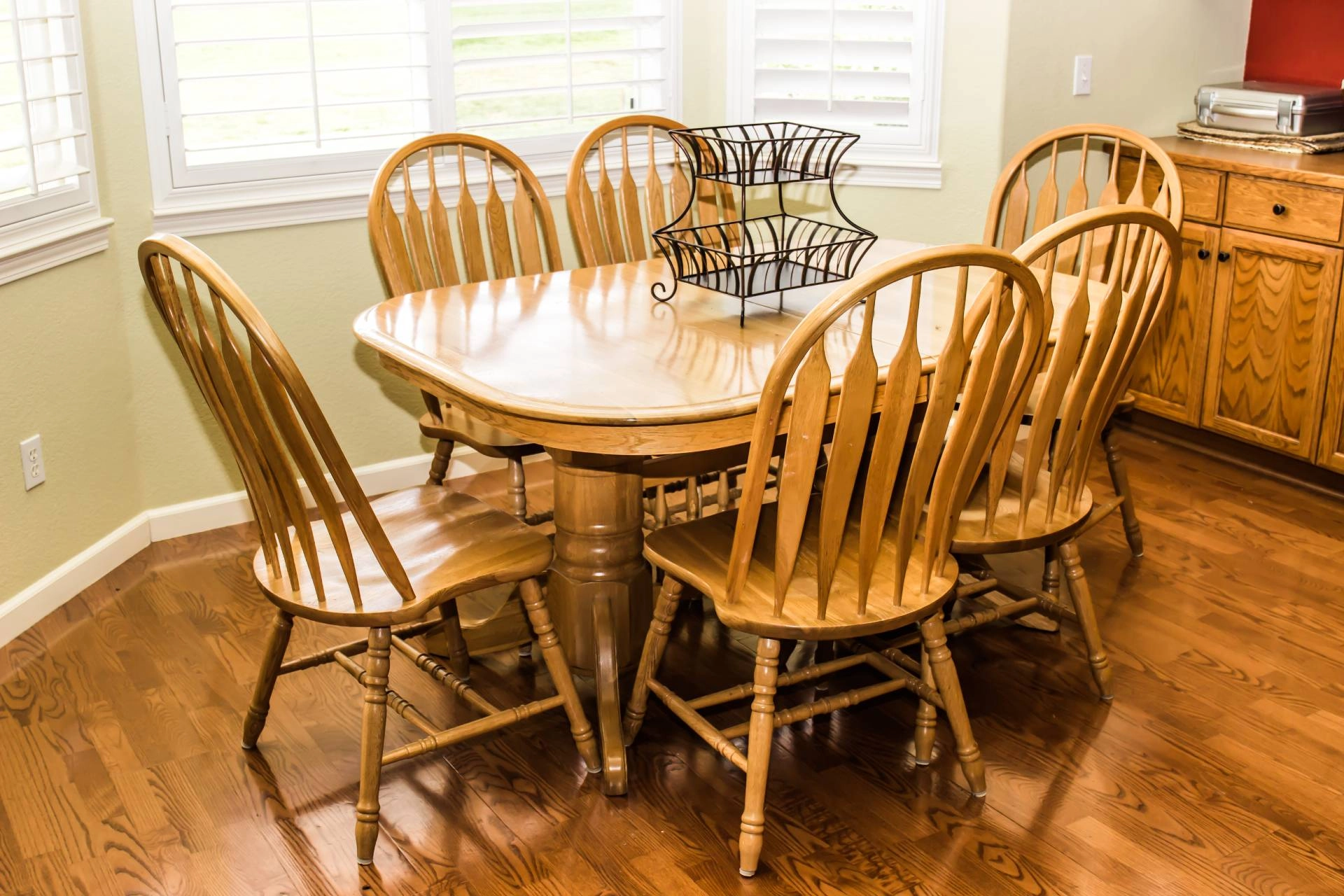White bay window shutters in a quaint kitchen with a wooden dining table and chairs near Silver Spring, MD