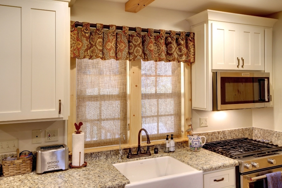 Kitchen windows above a sink featuring Hunter Douglas shades.