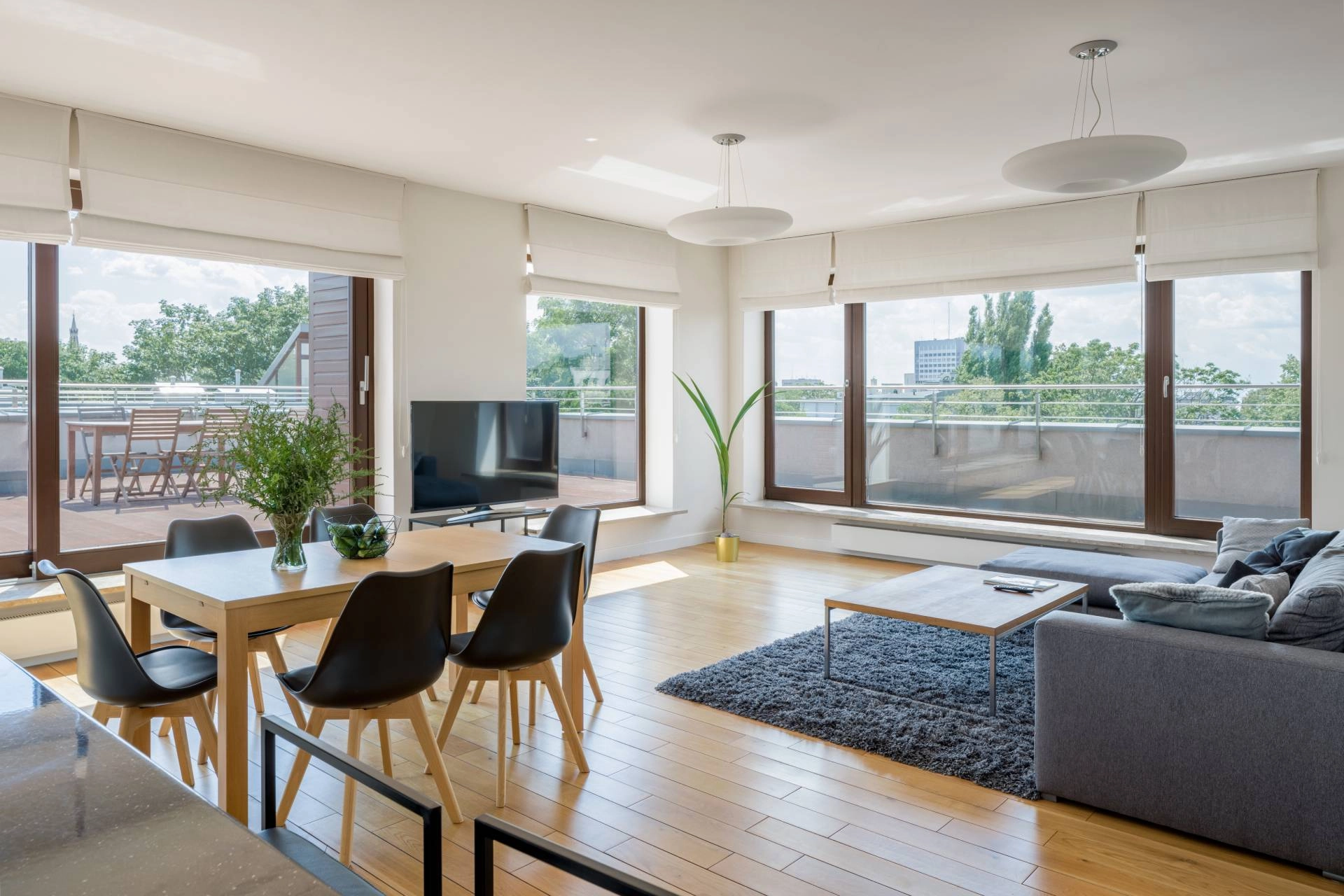 Motorized shades covering multiple large windows in an open-concept living room near Wexford, PA.