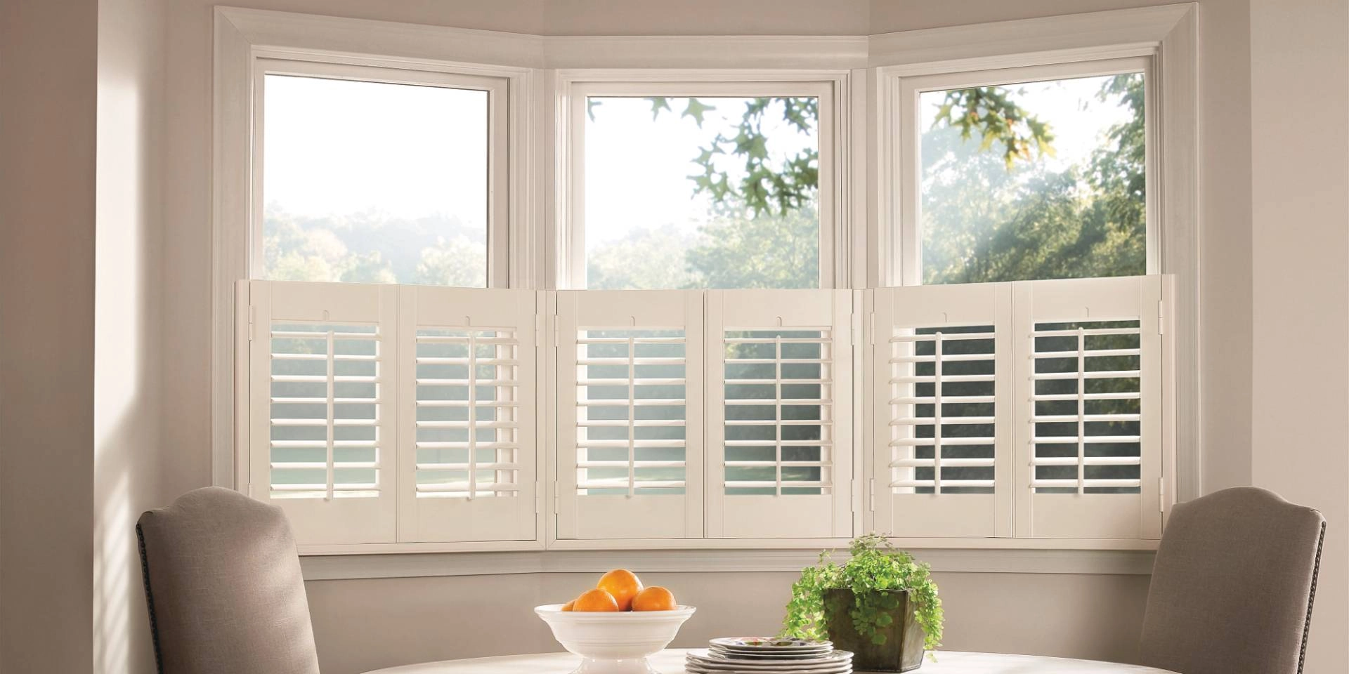 Gorgeous Hunter Douglas custom shutters in a cafe-style on windows in a breakfast nook