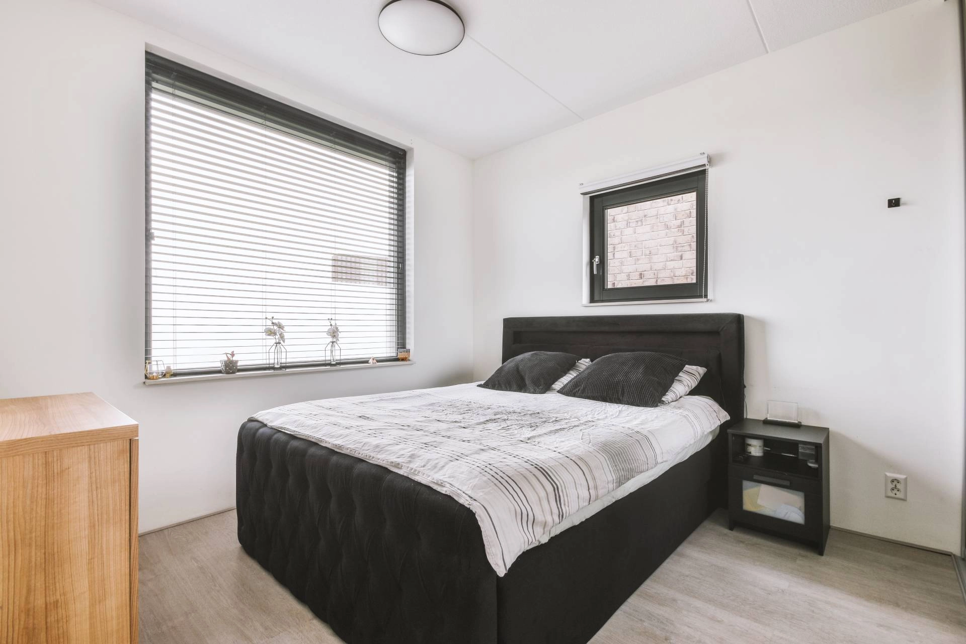 A modern bedroom with a set of sleek blinds near Springfield, MO