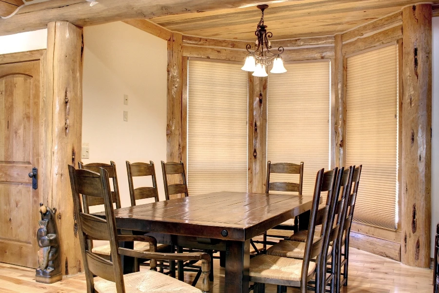 A dining room with windows featuring Hunter Douglas shades.