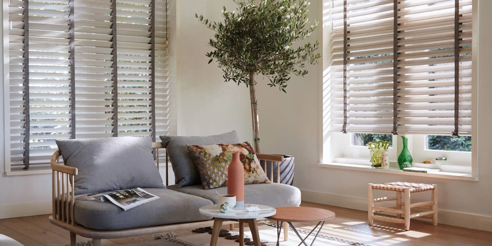 Hunter Douglas wooden blinds with decorative tapes on two windows in a contemporary living room