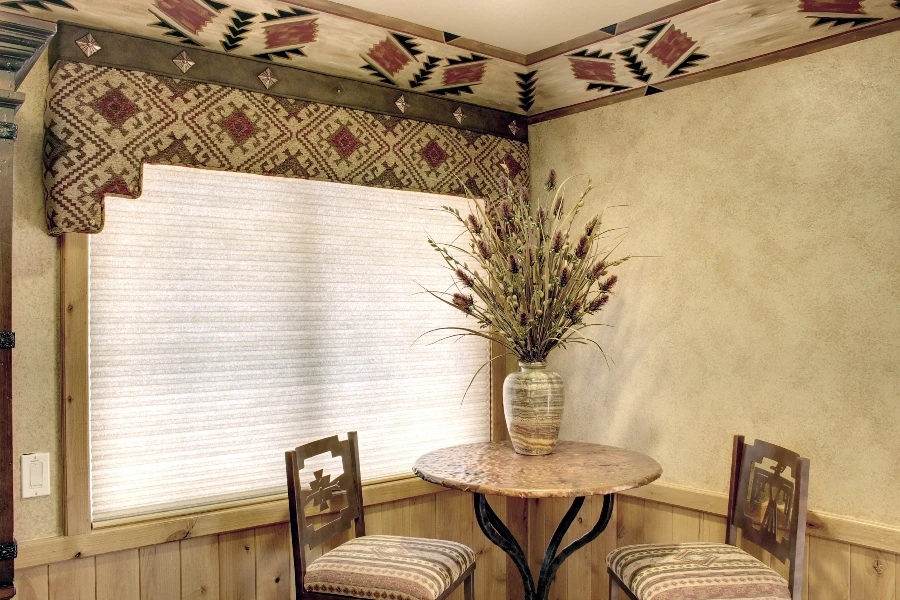 A bistro set in front of a window with Hunter Douglas shades.