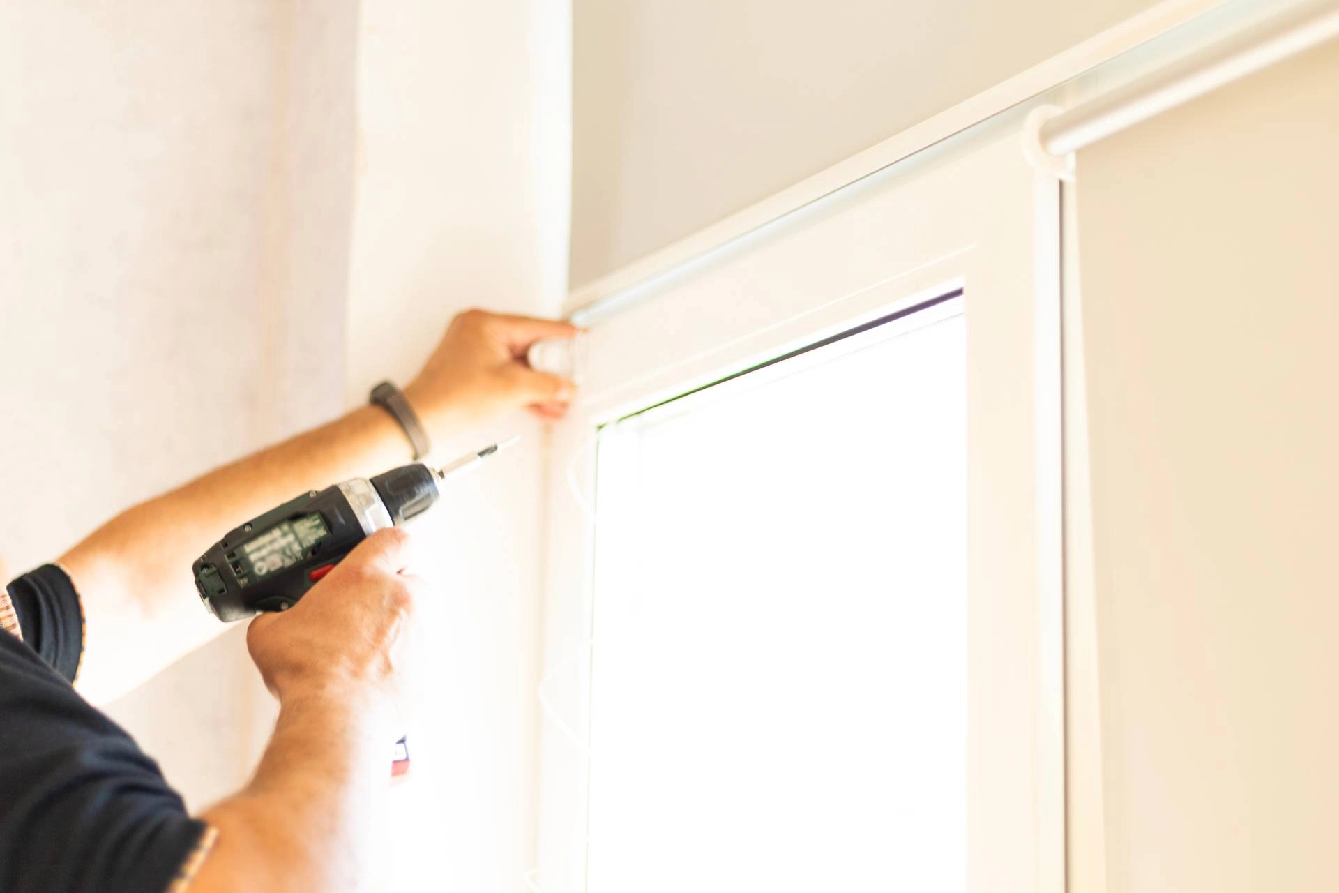Someone installing a set of roller shades near Arvada, Colorado (CO)