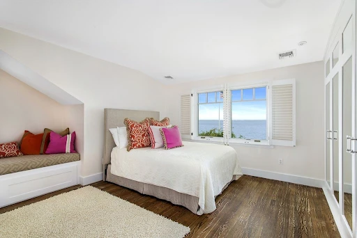 Bedroom windows with shutters. Bed with custom bedding.