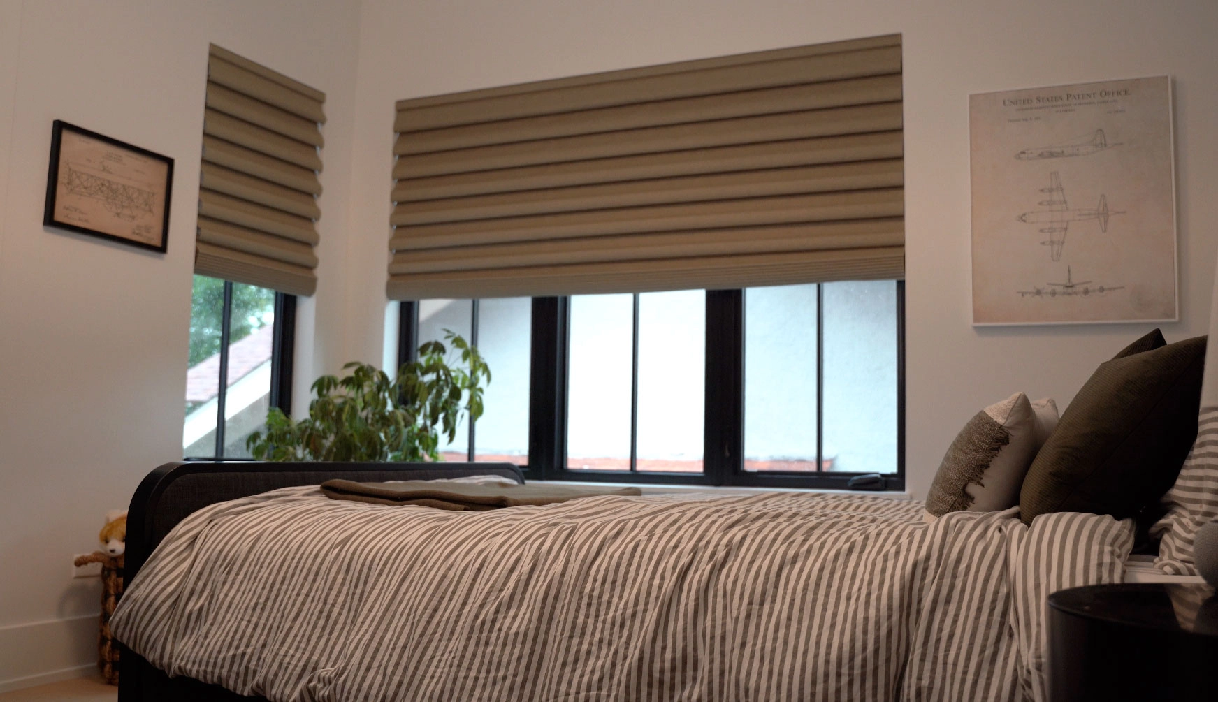 A bedroom with two windows featuring Hunter Douglas Roman shades.