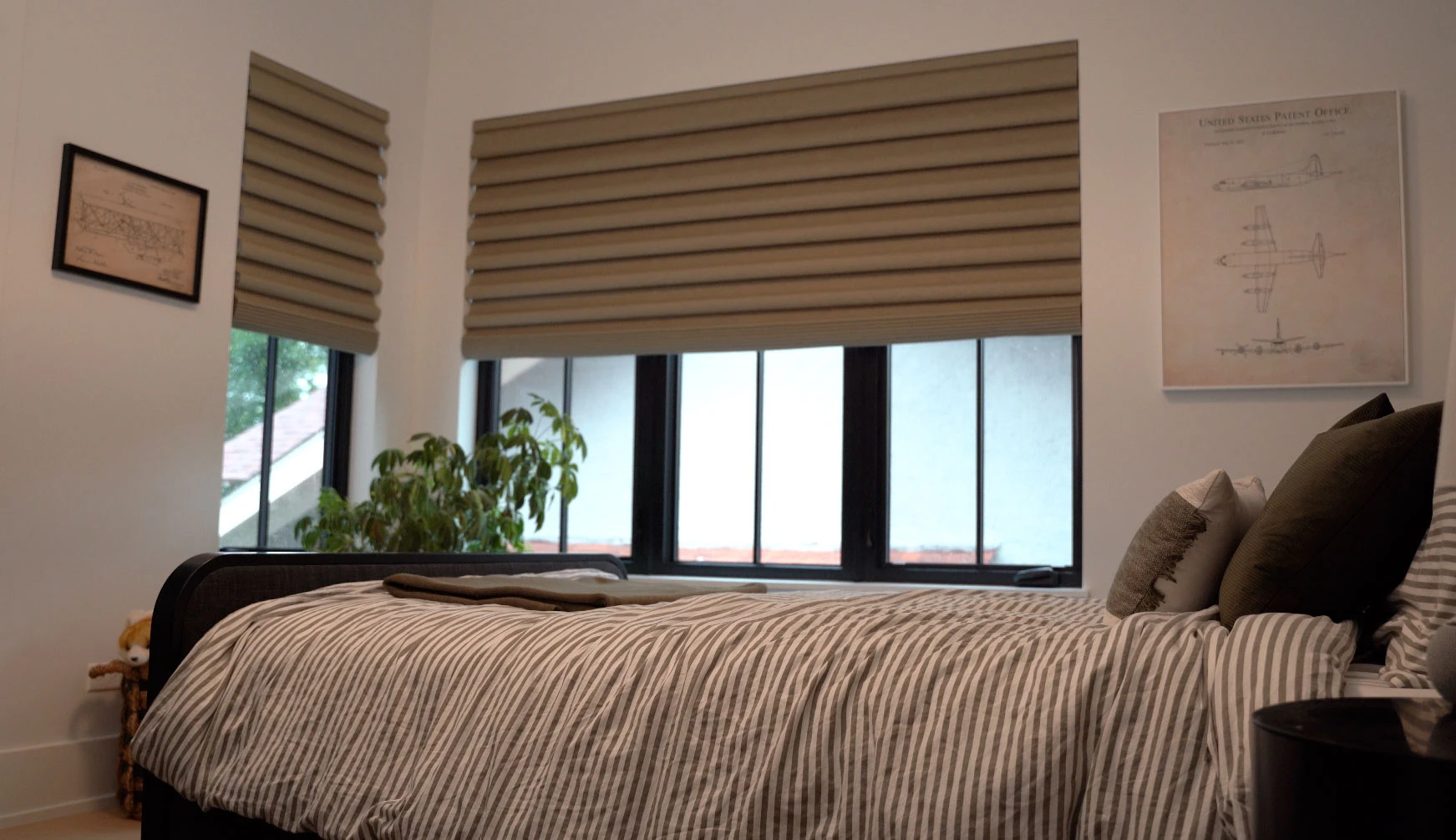 A bedroom with two windows featuring Hunter Douglas Roman shades.
